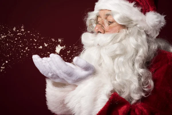 Weihnachtsmann bläst ein paar Schneeflocken — Stockfoto