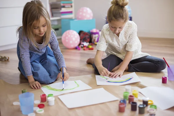 Kaksi tyttöä tekee maalauksia — kuvapankkivalokuva