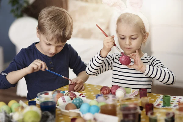 Children painting Easter eggs