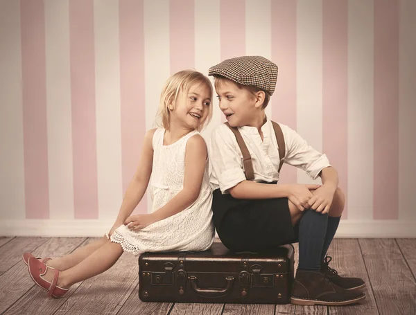 Niños sentados en la maleta de madera — Foto de Stock