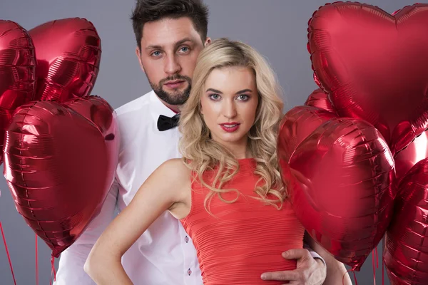 Couple avec ballons rouges en forme de coeur — Photo
