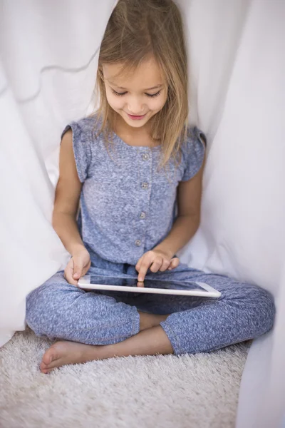 Girl Navegación tableta digital en el edredón — Foto de Stock