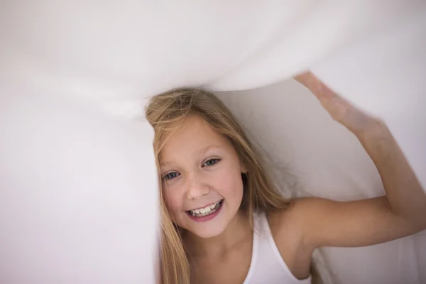 Kleines Mädchen versteckt sich unter dem Laken — Stockfoto