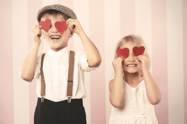 Two kids with hearts on the eyes clipart