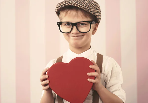 Muchacho sosteniendo señal de corazón rojo — Foto de Stock