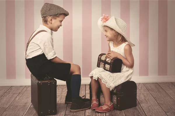 小女人和她的男孩坐在行李箱上 — 图库照片