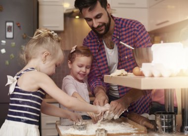 Family baking cookies in kitchen clipart