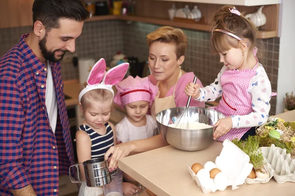 Children baking under watchful eye of parents — Stock Photo, Image