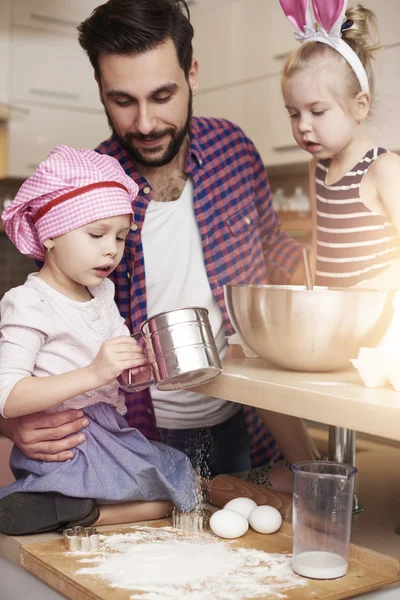 Батько з доньками під час випічки — стокове фото