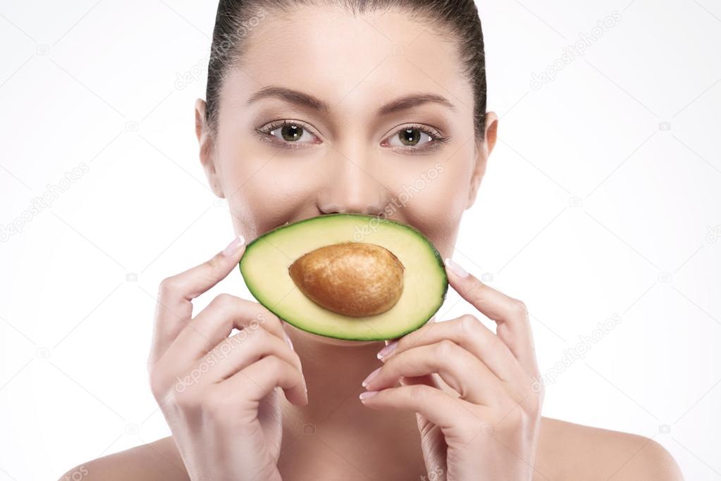 Woman holding avocado in hands