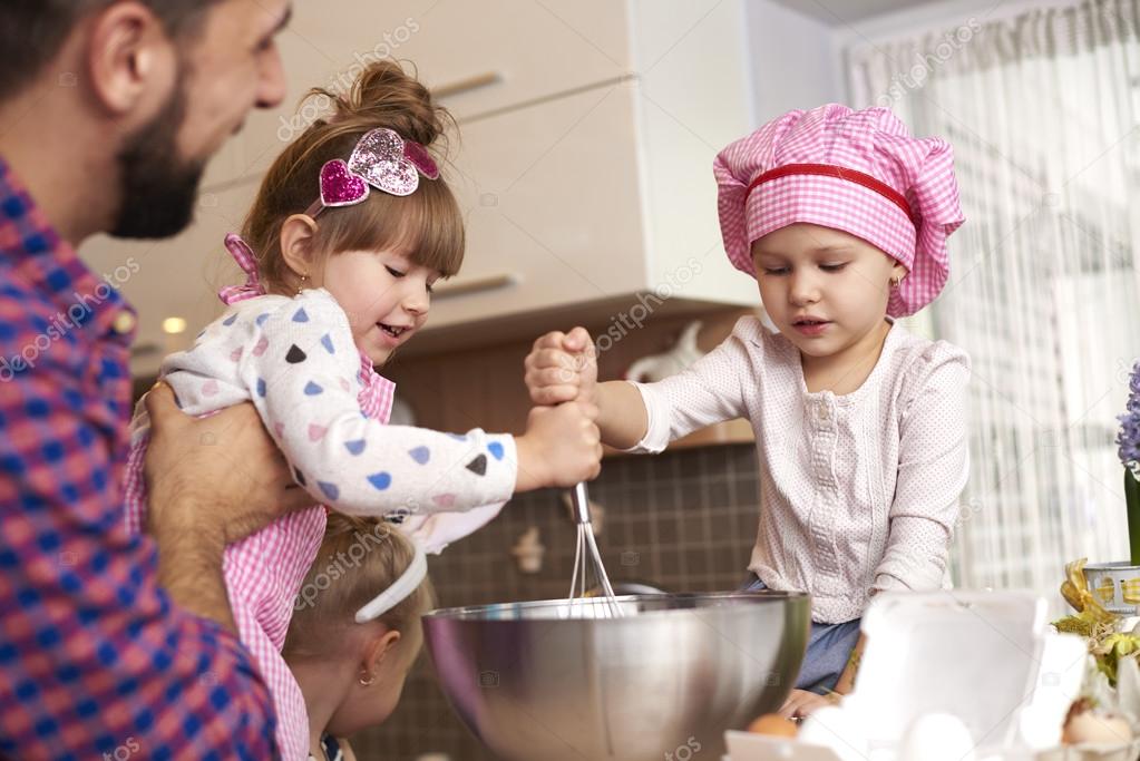 Daughters helping father with cooking