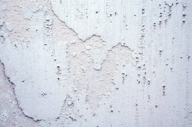 Beyaz çatlak alçı ve pürüzlü dokuya sahip gru grunge duvarı kapatın. Arka planlar, inşaat malzemeleri, yenileme projeleri ve yaratıcı tasarım için mükemmel.