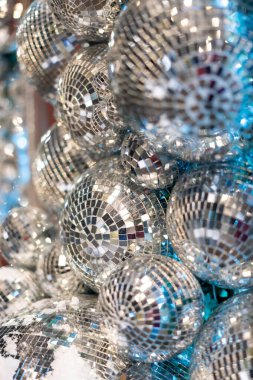 Ilık, parlak ışığı yansıtan parlak disko topları. Parıldayan yansımalarla şenlikli parti dekorasyonu, canlı ve büyüleyici bir tatil atmosferi yaratıyor. Kutlama ve etkinlik temaları için mükemmel