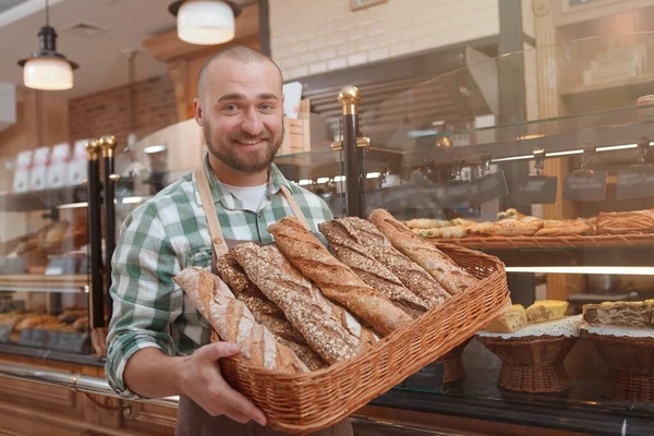 Feliz Jovem Padeiro Sorrindo Para Câmera Carregando Pão Recém Assado — Fotografia de Stock