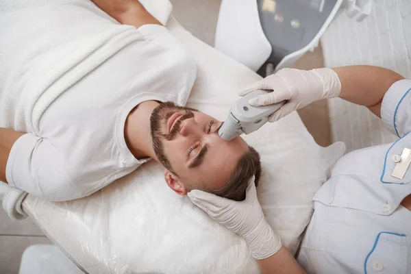 Bonito Homem Barbudo Relaxante Clínica Beleza Recebendo Tratamento Laser Facial — Fotografia de Stock