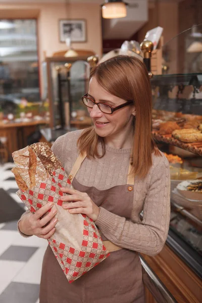 Vertical Shot Proud Female Baker Looking Freshly Baked Bread Her — Stock Photo, Image