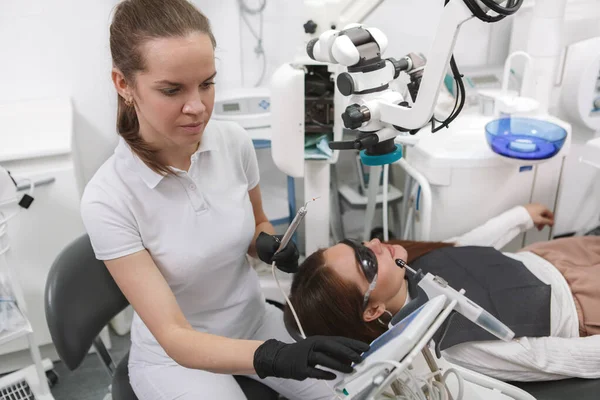 Снимок Женщины Стоматолога Работающей Пациенткой Зубным Микроскопом — стоковое фото