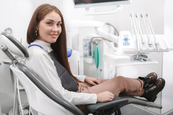 Happy woman with healthy white teeth smiling to the camera after dental checkup