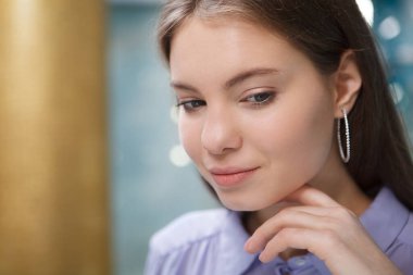 Elmas halkalı küpe takan çekici bir kadına yaklaş.