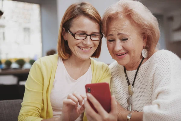 Mutlu bir anne ve orta yaşlı kızının akıllı telefonları kullanarak uzayın fotokopisini çekmelerini istiyorum.