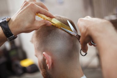 Bir adamın saçını profesyonel berbere kestirirken çekilmiş görüntüsü.