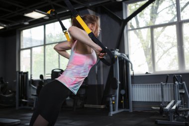 Spor salonunda Trx eğitmeni ile çalışan bayan sporcu, boşluğu kopyala