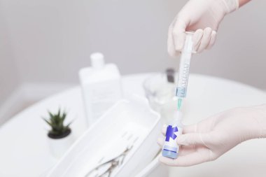 Tanınmayan manikürcü temizlik aletleri için dezenfektan çözeltisi hazırlıyor