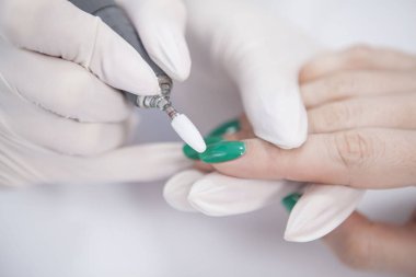 Manikürcüyü tırnak törpüsü kullanarak kapat, tırnak jölesini çıkar.