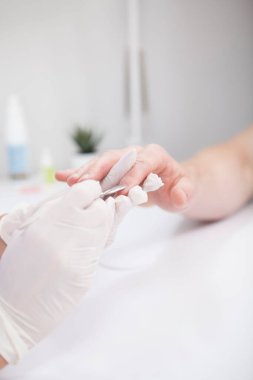 Erkek ellerine manikür yapan profesyonel manikürcünün dikey görüntüsü.