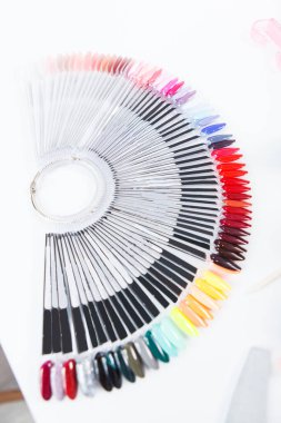 Manikürcüler masasında renkli tırnak cilası paletinin dikey üst görüntüsü