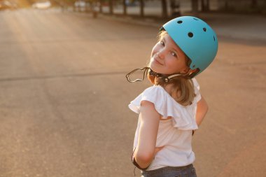 Omzunun üzerinden kameraya gülümseyen, dışarıda koruyucu miğfer takan, uzayın fotokopisini çeken çekici bir genç kız.
