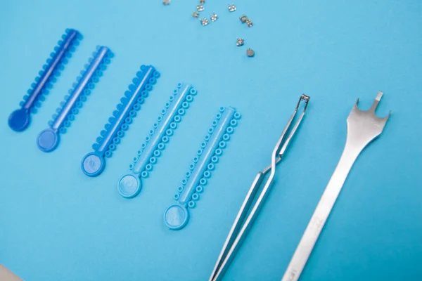 Tirantes Elásticos Instrumentos Dentales Sobre Fondo Azul — Foto de Stock