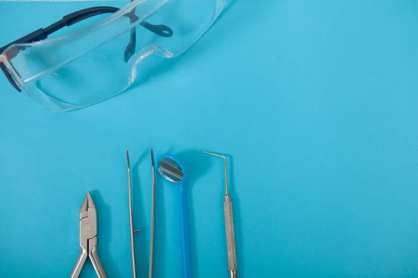 Vista Superior Cercana Anteojos Protectores Instrumentos Dentales Sobre Fondo Azul — Foto de Stock