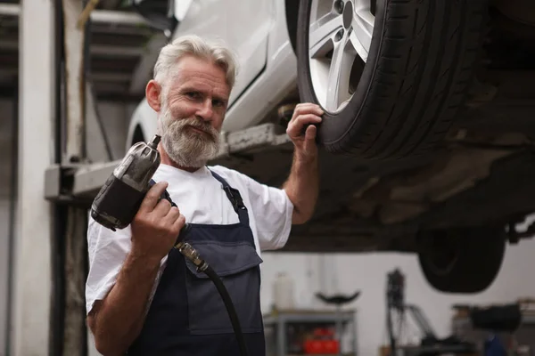 Elderly Bearded Car Service Worker Holding Torque Wrench Standing Lifted — Stock Photo, Image