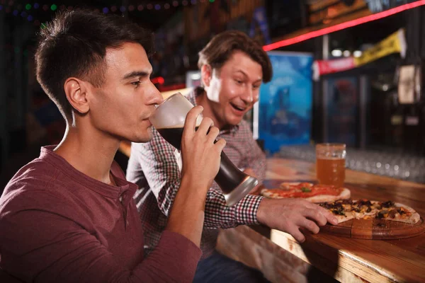 Молодой Человек Потягивает Пиво После Пиццы Своим Другом Баре — стоковое фото