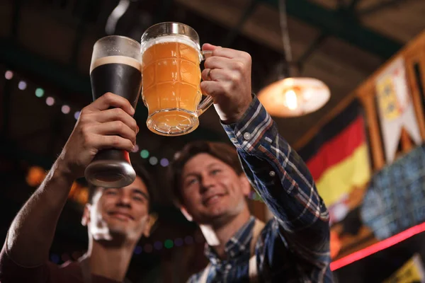 Nízký Úhel Záběru Dvou Šťastných Pivovarů Připíjejících Cinkajících Pivními Brýlemi — Stock fotografie