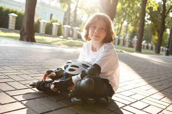 Αξιολάτρευτο Νεαρό Αγόρι Που Φοράει Πατίνια Κάθεται Στο Έδαφος Στον — Φωτογραφία Αρχείου