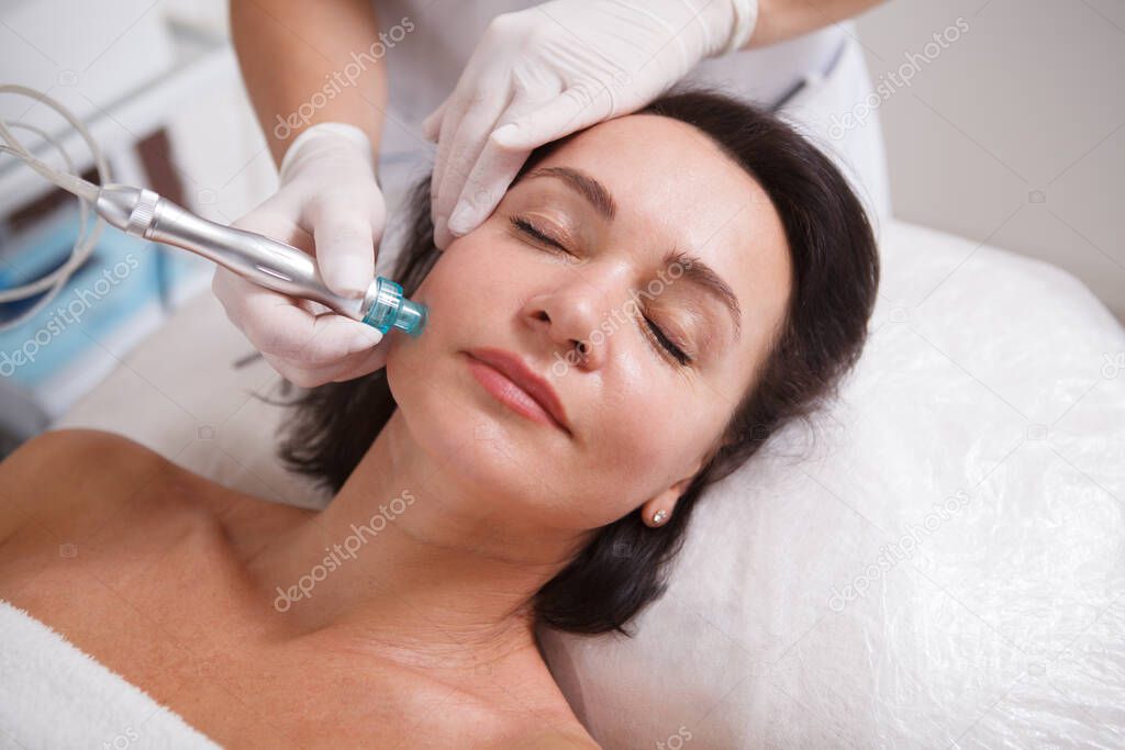 Close up of a mature woman getting hydra skincare facial cleanse at beauty salon