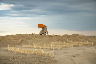 Hollanda 'nın Markermeer kentindeki Marker Wadden' da, kum tepelerinde kuş izleme kulesi ve ahşap yapı çitleri var..