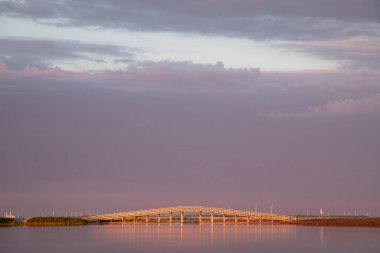 Gün batımında Markerwadden Köprüsü 'nde. Marker Wadden, Hollanda 'nın Markermeer şehrinde geliştirilen yapay takımada..