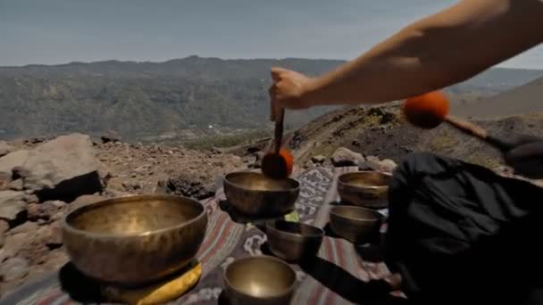 一个年轻的亚洲人在大自然的观光山上弹奏着Tibedt铜杯 — 图库视频影像