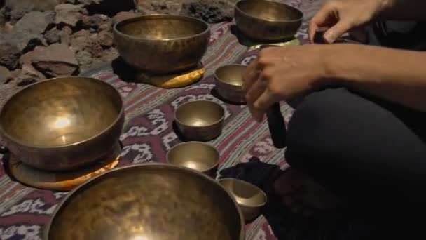 一个年轻的亚洲人在大自然的观光山上弹奏着Tibedt铜杯 — 图库视频影像