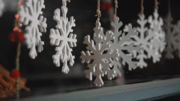白色的圣诞小饰品挂在房子玻璃后面的线上 — 图库视频影像