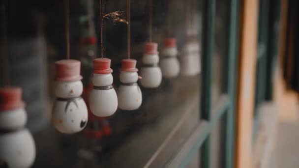Маленькі Білі Різдвяні Іграшки Сніговики Висять Нитці Склом Будинку — стокове відео