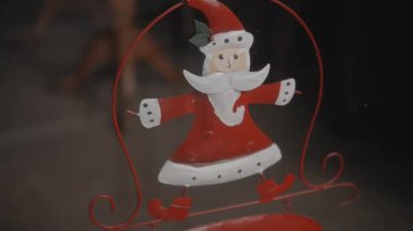 Evdeki küçük kırmızı Noel oyuncakları Noel Baba 'nın camında asılı.