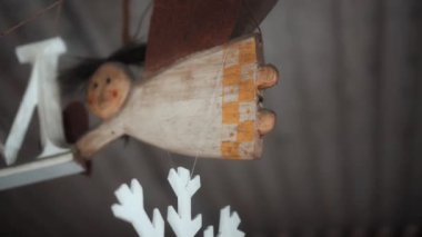 Küçük Noel ağacı evde asılı melek oyuncaklarını renklendirir.