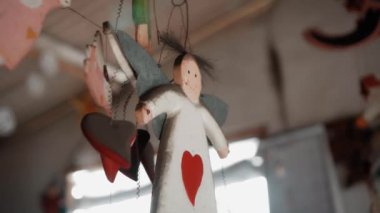 Küçük Noel ağacı evde asılı melek oyuncaklarını renklendirir.