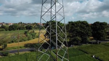 Yeşil pirinç tarlasında yeni inşa edilmiş bir elektrik iletim kulesinin hava aracı görüntüsü