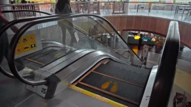 Kuta, Kabupaten Badung, Bali, Endonezya - 6 Kasım 2020: Toplumsal mesafeyi korumak için ayak izi işareti olan bir alışveriş merkezinde siyah merdiven yürüyen merdiven