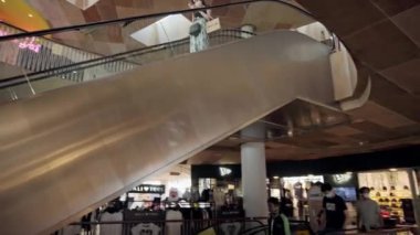 Kuta, Kabupaten Badung, Bali, Endonezya - 6 Kasım 2020: Toplumsal mesafeyi korumak için ayak izi işareti olan bir alışveriş merkezinde siyah merdiven yürüyen merdiven